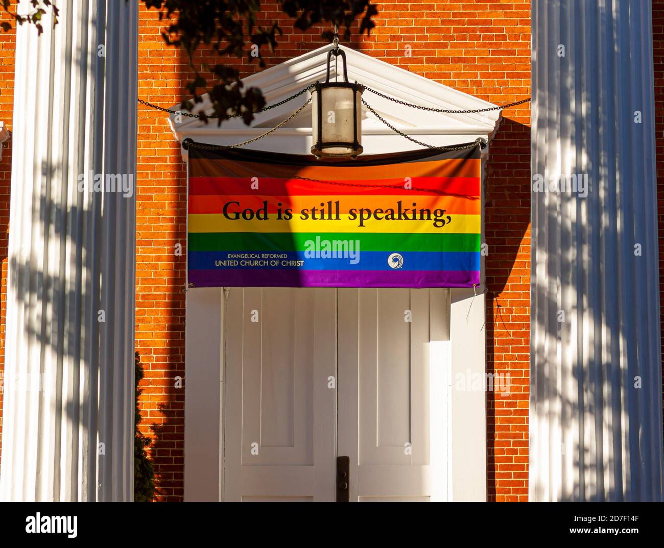 Frederick, MD, USA 10/13/2020: Close up image of the front door of the Evangelical Reformed United Church of Christ with a large LGBT flag that says G Stock Photo