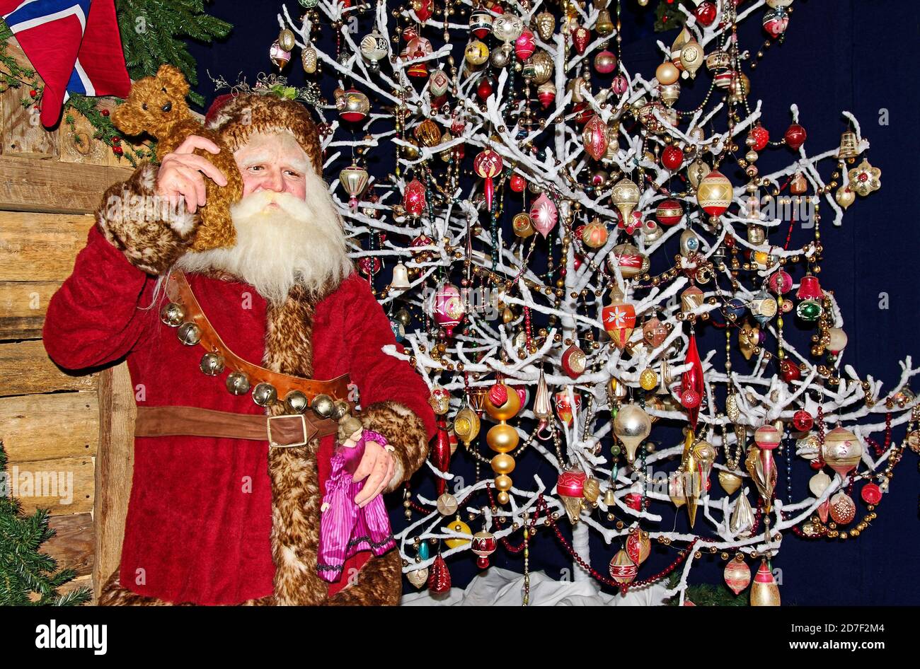 National Christmas Center, Lancaster County, , Pennsylvania Santa Claus figure, holding Teddy  bear & doll, red velvet suit, fur trim, decorated white Stock Photo