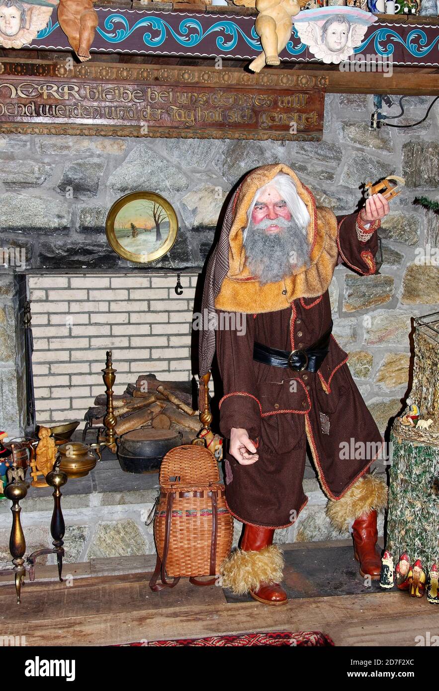 Weinhnachtsmann of Germany, figure holding wood toy, woven basket, stone fireplace, Christmas scene, holiday, Paradise, PA Stock Photo