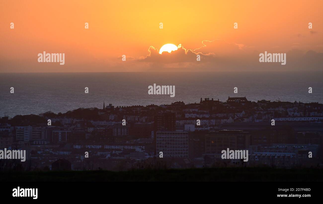 Brighton UK 22nd October 2020 - The sun sets over Brighton seen from Tenantry Down to the east of the city as unsettled weather is forecast to spread across Britain over the next few days : Credit Simon Dack / Alamy Live News Stock Photo