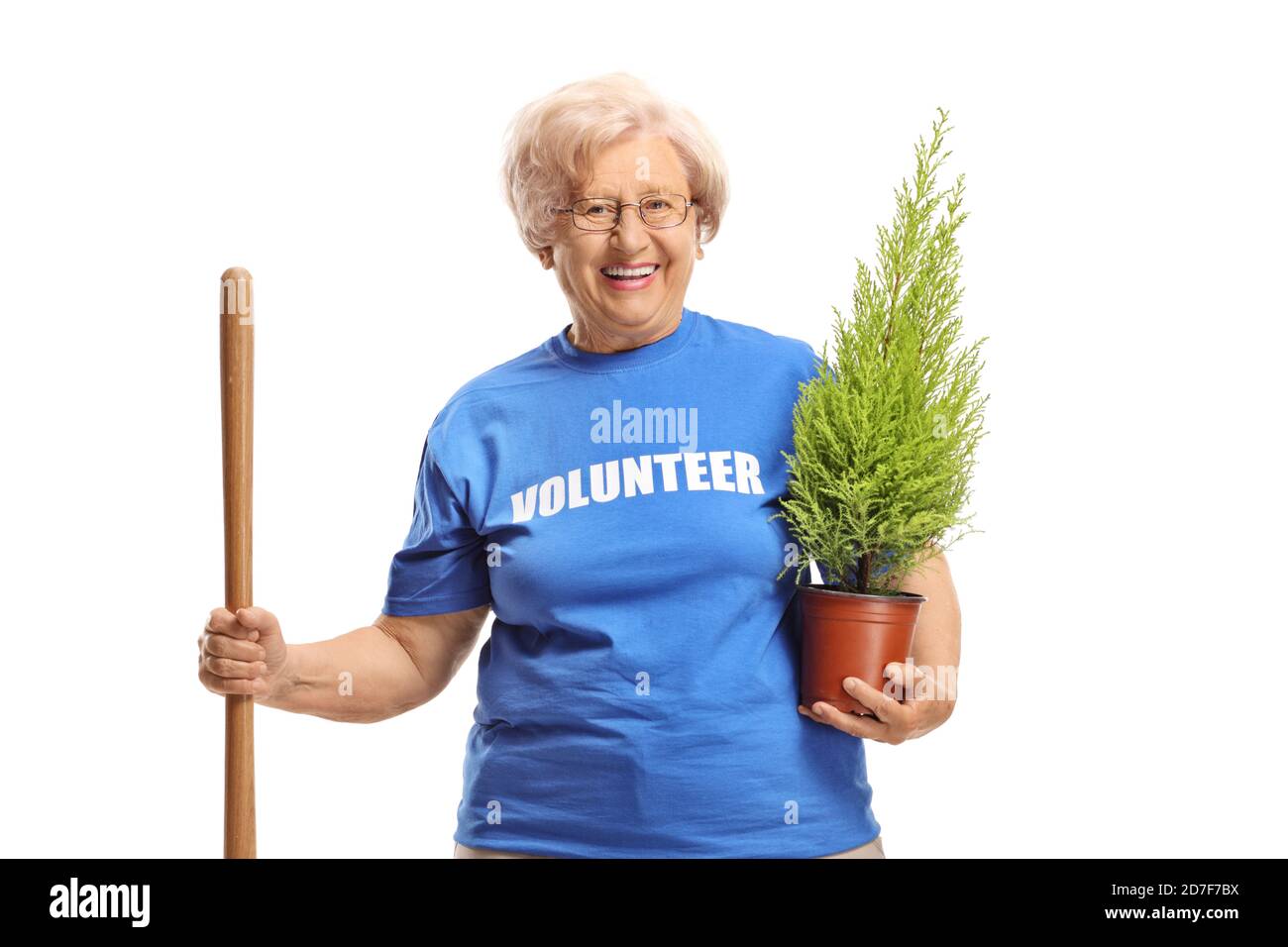 Elderly woman volunteer with a shovel and a plant isolated on white background Stock Photo