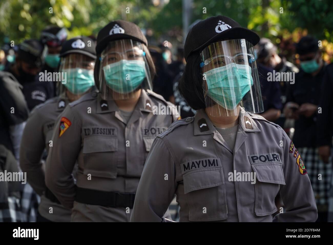 Denpasar, Bali, Indonesia. 22nd Oct, 2020. Police women standby in line wearing faceshields. Students and laborers staged again the second mass rallies called ''Bali Tidak Diam'' (Bali are Not Silent) in front of Udayana University, to support Indonesian laborers of the new rule; Omnibus Law. This new law was created by Indonesian parliament which fears of crippling laborers rights and harm the environment. Credit: Dicky Bisinglasi/ZUMA Wire/Alamy Live News Stock Photo