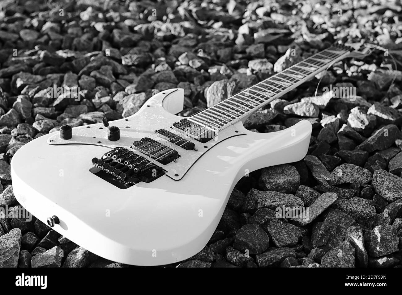 black and white electric guitar on the railroad tracks and industrial