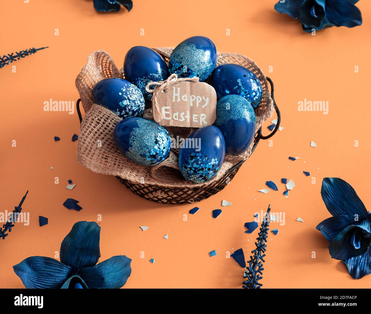 Creative Easter layout made of colorful eggs and flowers on blue ...