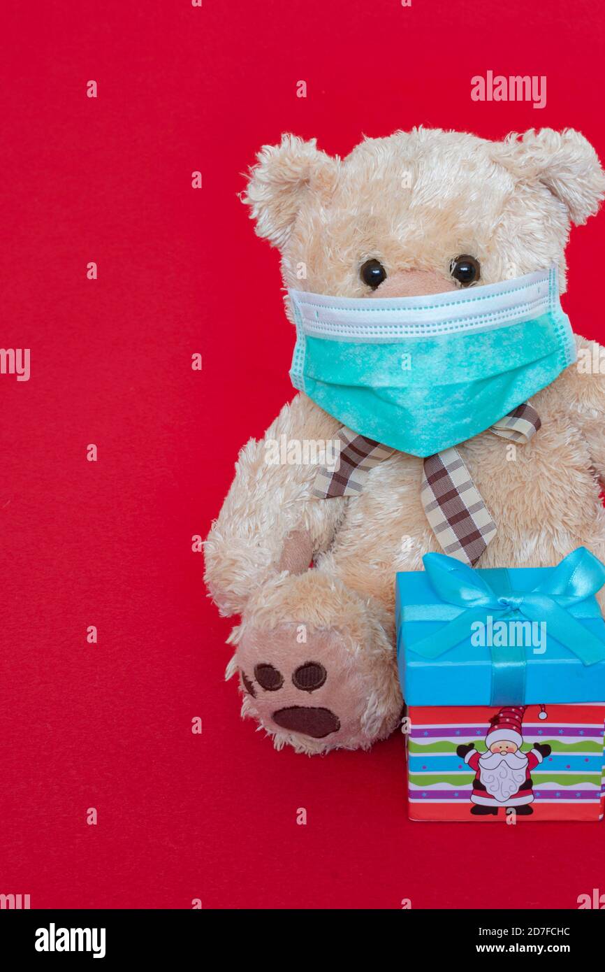 Teddy bear with face mask and gift box Stock Photo