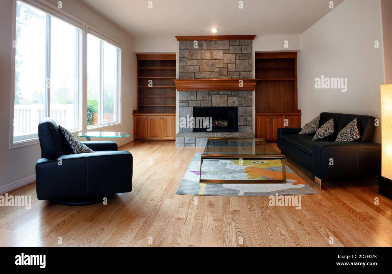 Family room remodeled with gas insert fireplace operating in background Stock Photo