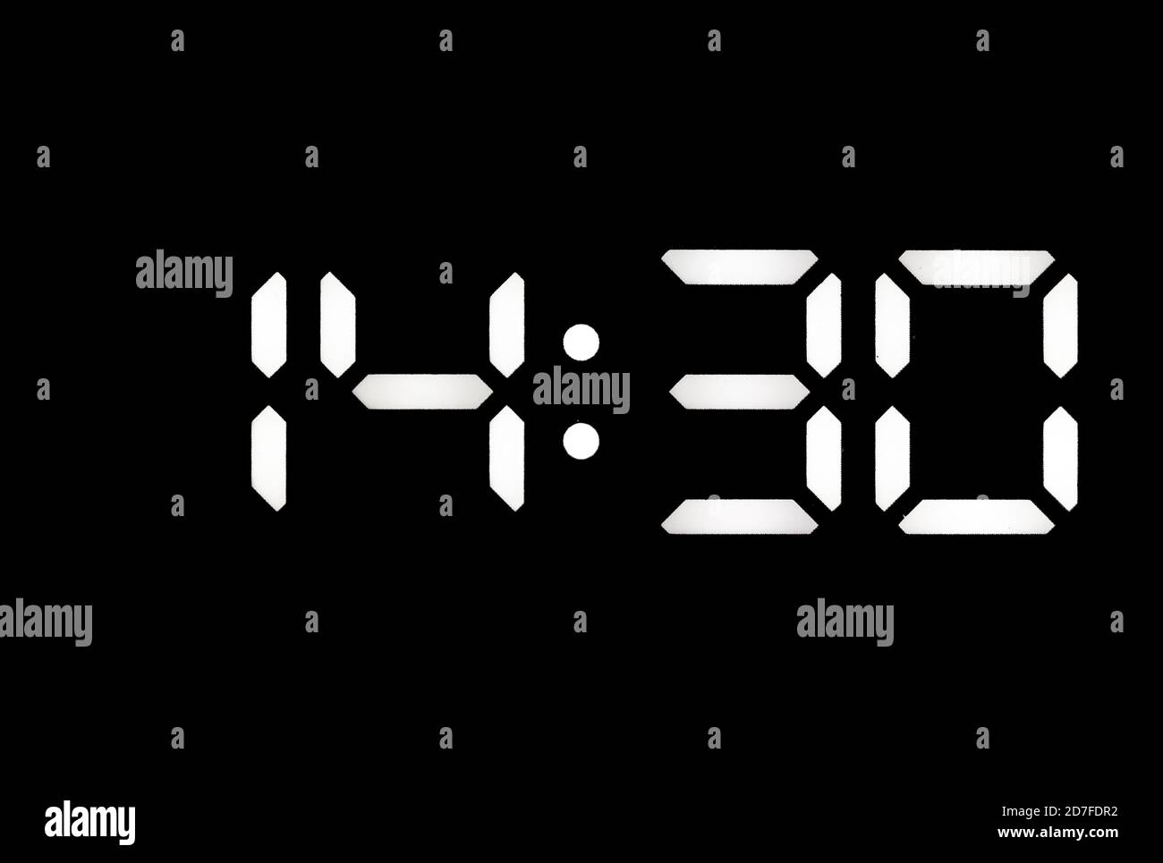 Real white led digital clock on a black background showing time 14:30 Stock Photo