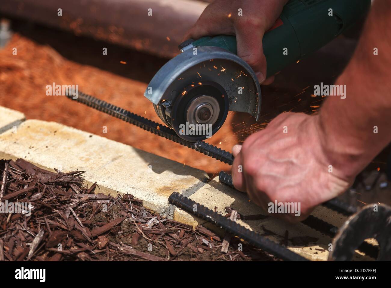 Worker cuts metal rods with an angle grinder Stock Photo Alamy