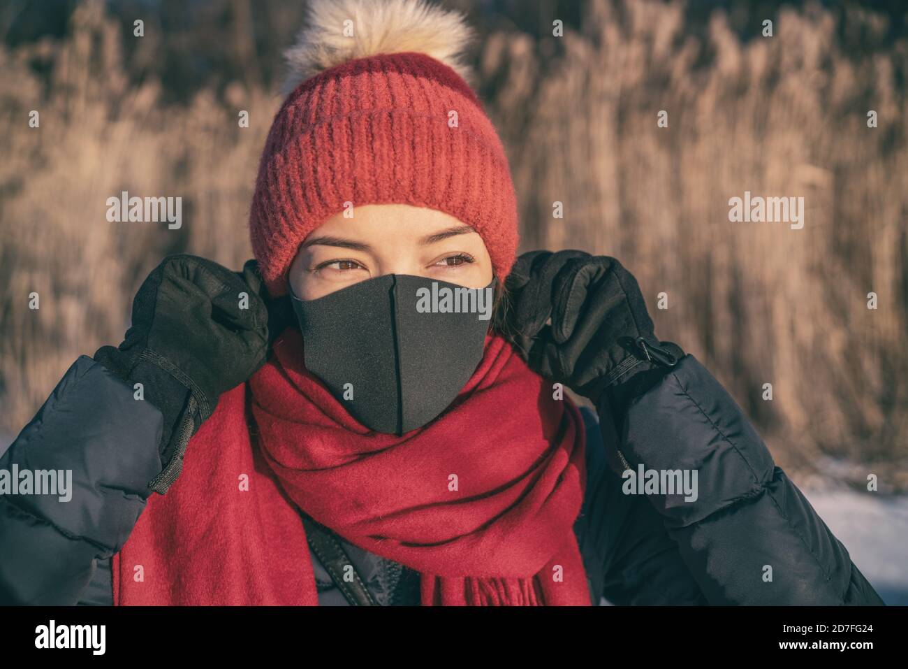 Coronavirus and Covid 19 mask for protection. Also against winter smog bad air pollution Asian woman wearing mask to breathe outside cold air Stock Photo