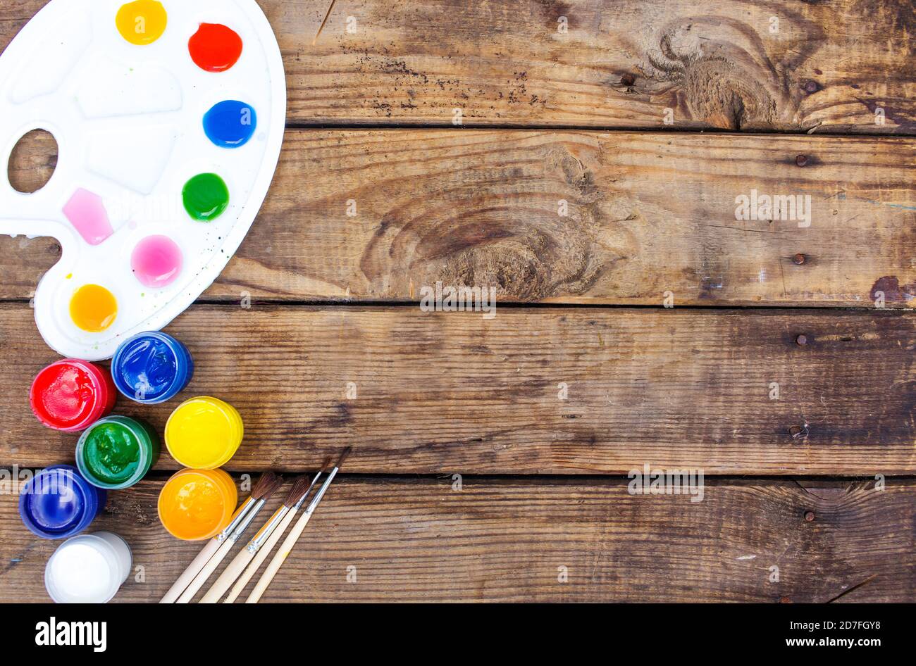 multi-colored paints,brushes palette, brush,lie on a wooden background top view Stock Photo