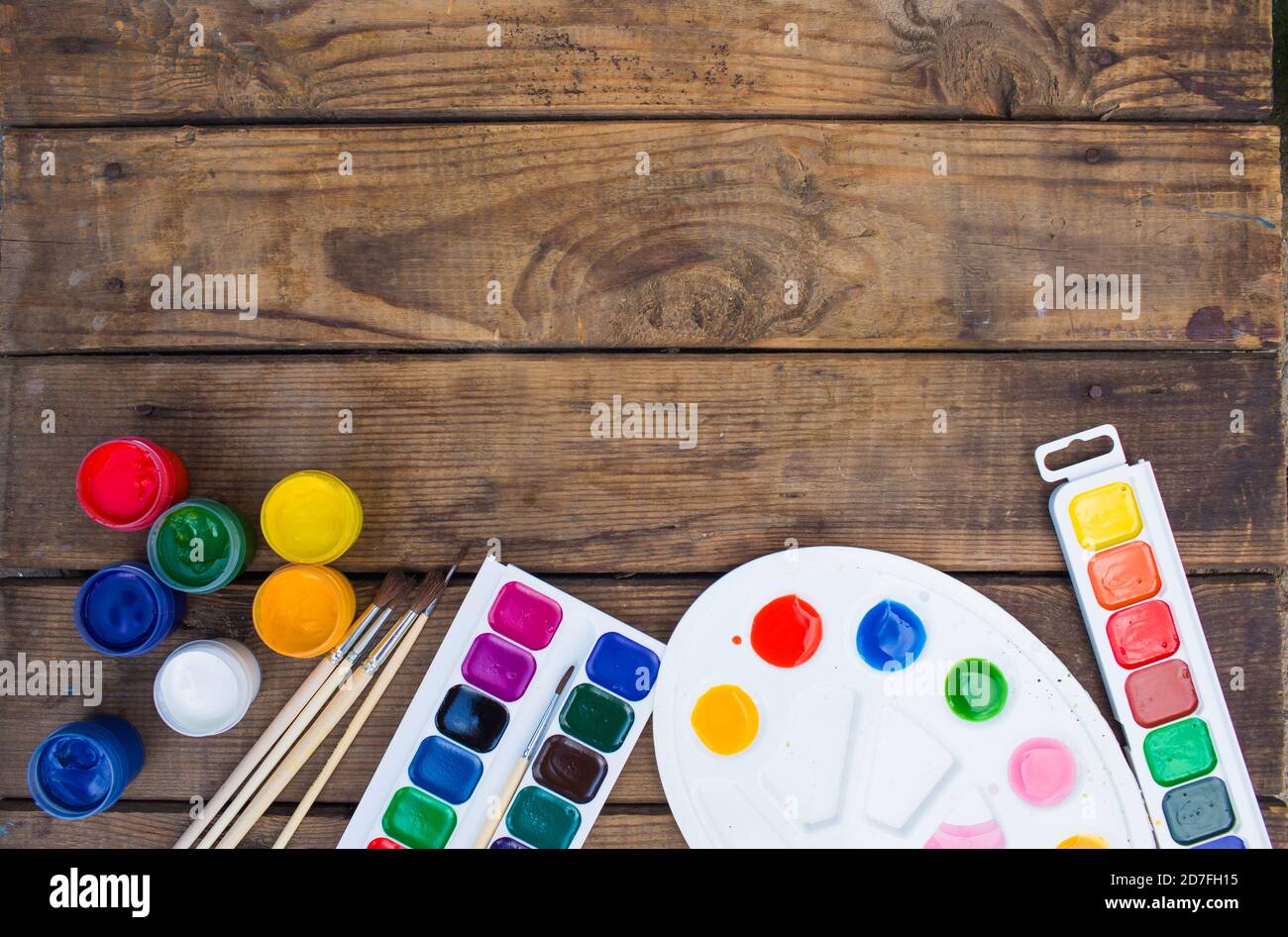 multi-colored paints,brushes palette, brush,lie on a wooden background top view Stock Photo
