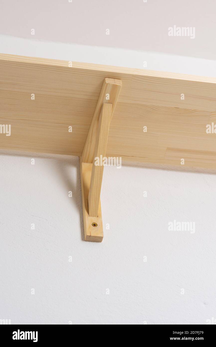 The process of attaching a wooden shelf to the wall, shelf corners