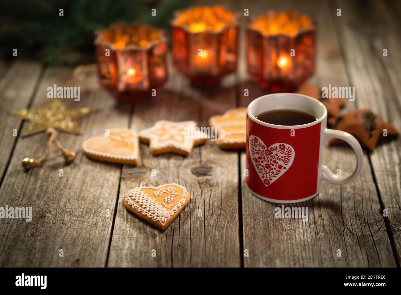 Homemade Christmas mulled wine punch with gingerbread on wooden rustic table. Burning candles in background. Traditional autumn and winter hot drink. Stock Photo