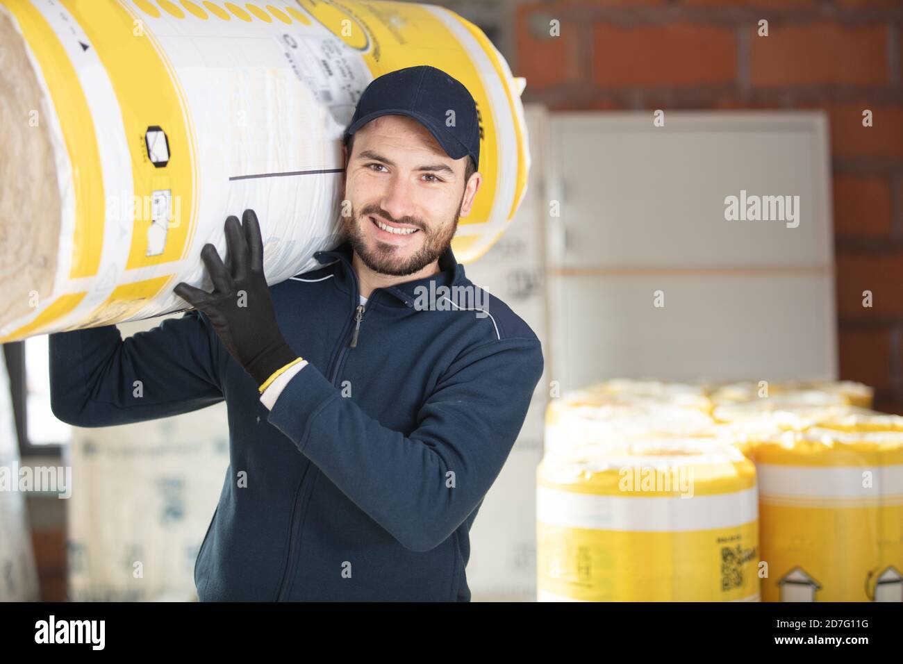 carrying a glass wool roll for insulation purpose Stock Photo