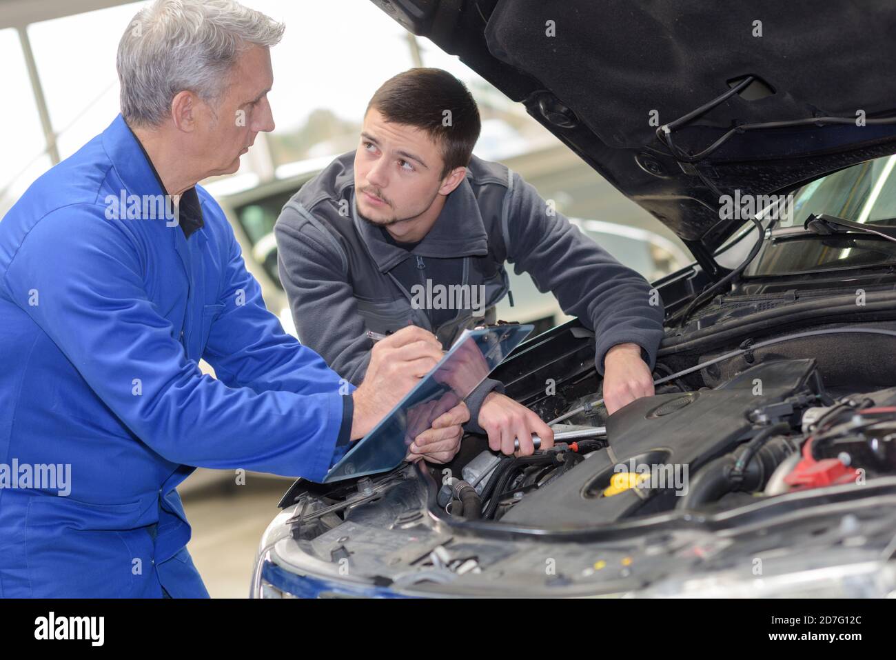 apprentice automotive mechanic and professor at work Stock Photo Alamy