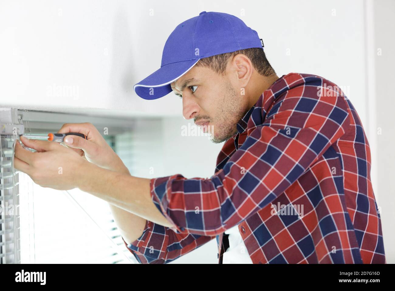 construction worker repairing window in house Stock Photo