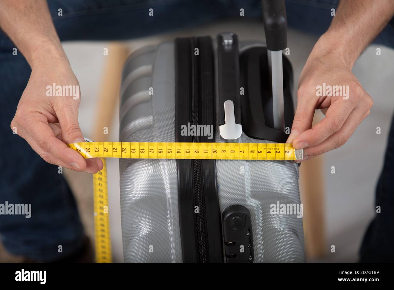 man measuring luggage size with measure tape Stock Photo Alamy