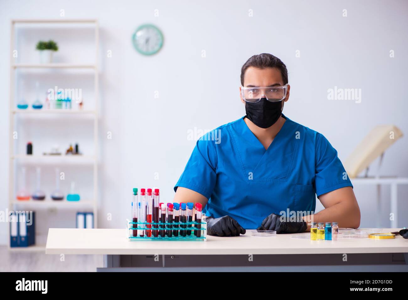 Male biochemist testing blood samples in pandemic concept Stock Photo ...