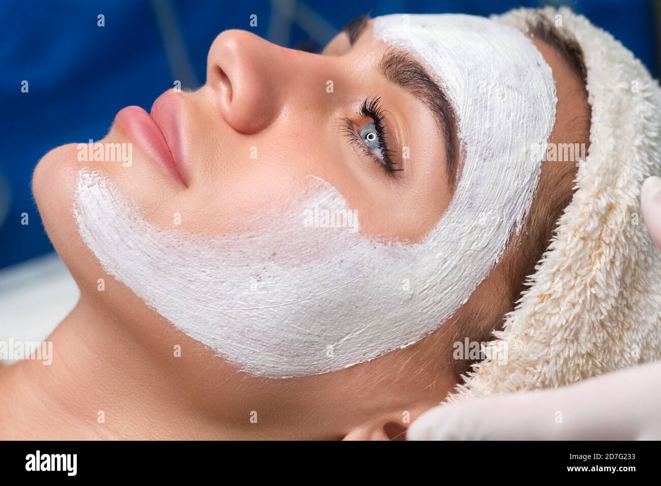 Applying a mask to the face in a beauty salon. Cosmetologist and procedure for rejuvenation and moisturizing. Stock Photo