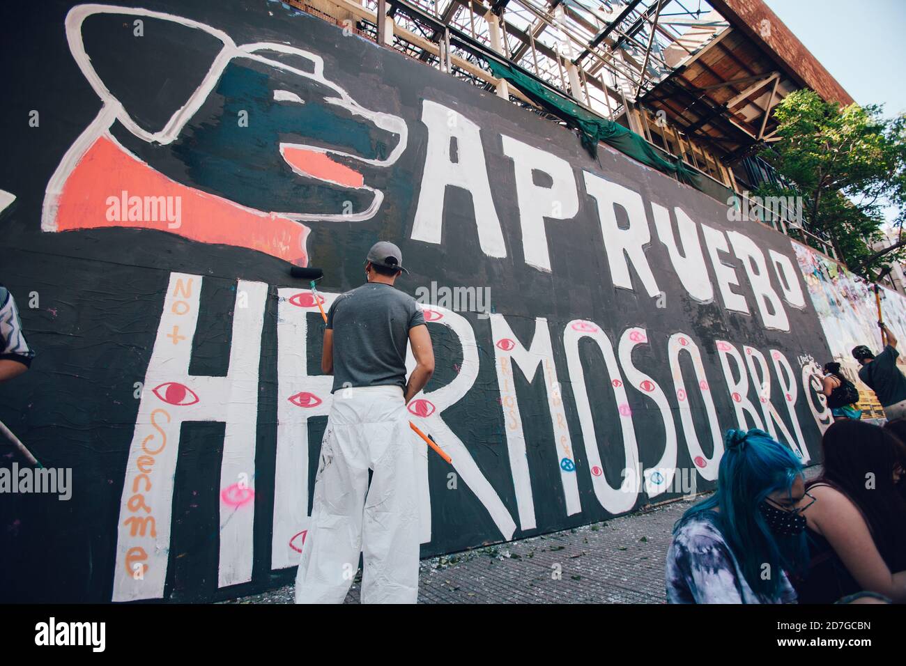 SANTIAGO, CHILE-OCTOBER 18, 2020 - Young people from the Ramona Parra Brigade, paint a mural allusive to the first anniversary of the social outbreak Stock Photo