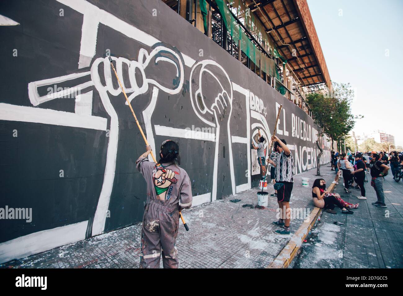 SANTIAGO, CHILE-OCTOBER 18, 2020 - Young people from the Ramona Parra Brigade, paint a mural allusive to the first anniversary of the social outbreak Stock Photo