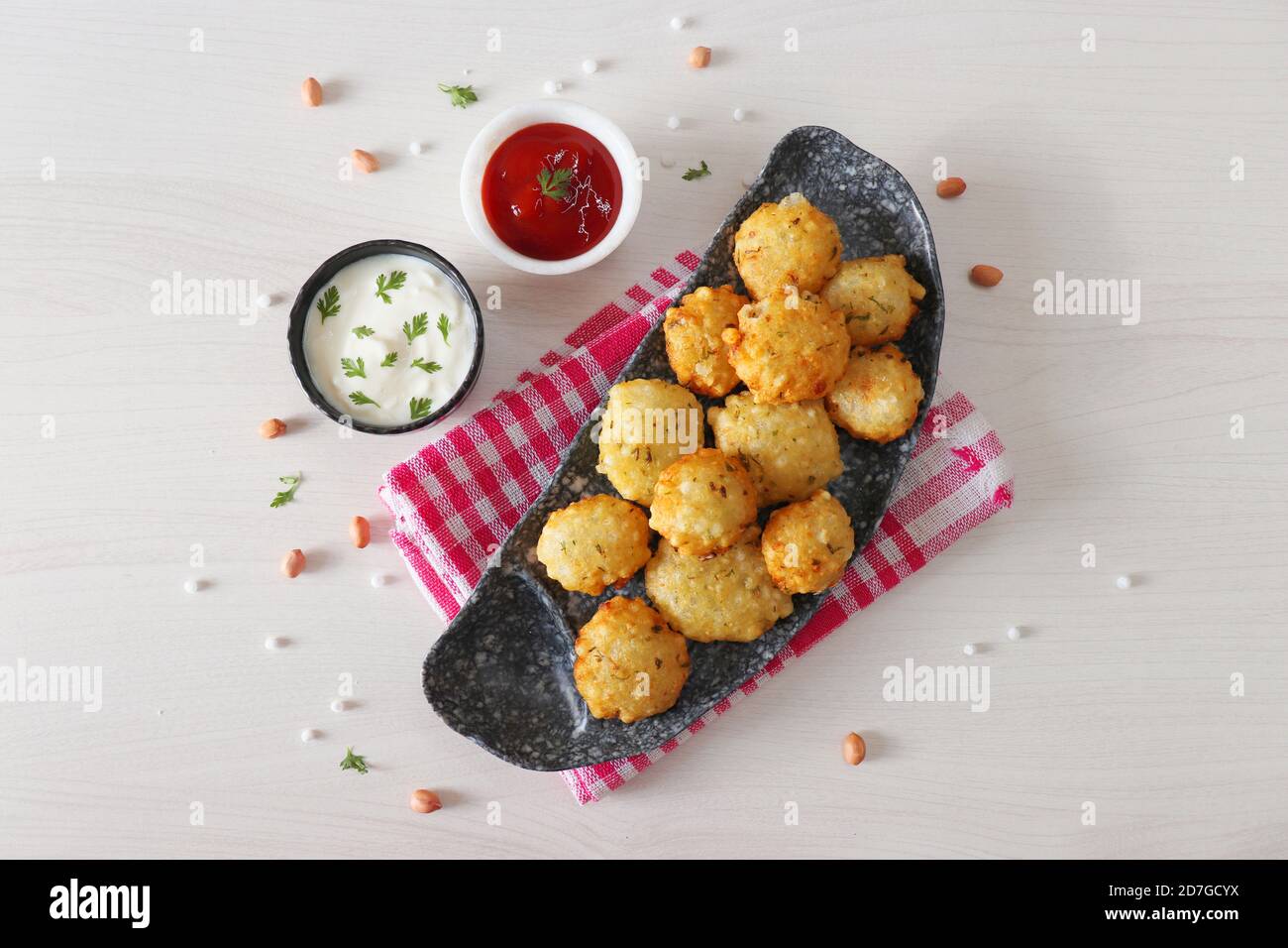 Sabudana vada or Sago fried fitters served with Curd or yogurt and ketchup over white wooden background, popular fasting recipe from India Stock Photo