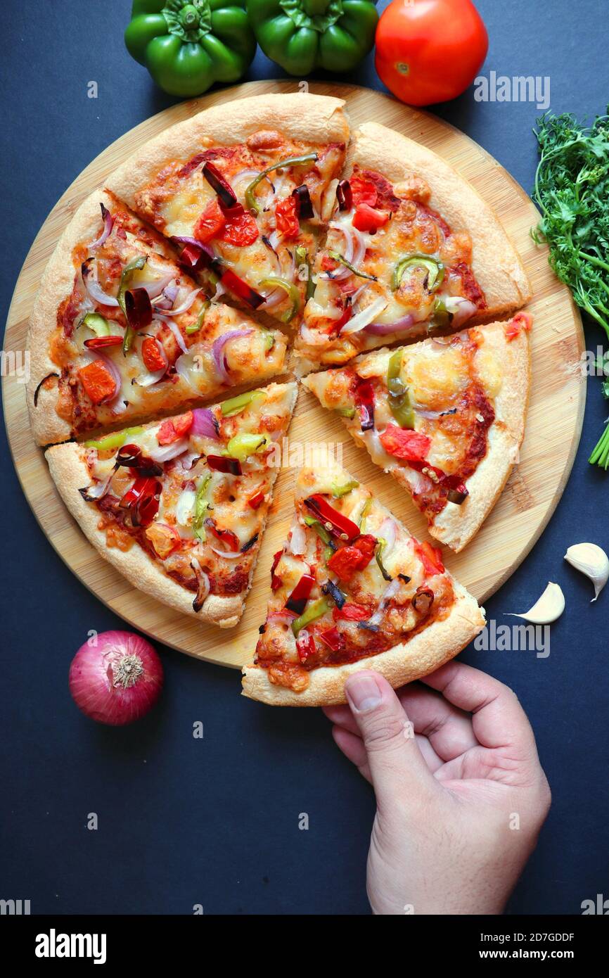 Traditional Italian veggie pizza. Toppings are capsicum, corn, tomatoes, onion, red chilies, and cheese. Ingredients and vegetable background Stock Photo - Alamy
