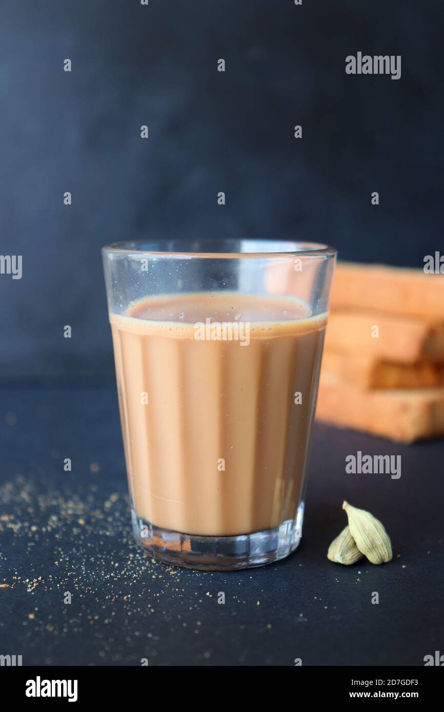 Tea Time Snack - Healthy Wheat rusk served with Indian hot masala tea, over black background with the cardamom. also known as Mumbai cutting chai. Stock Photo