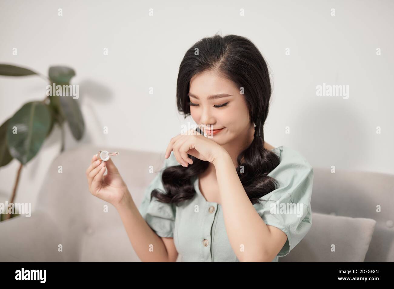 Pretty young woman showing how hyaluronic acid looks like isolated. Female using anti age product . Stock Photo