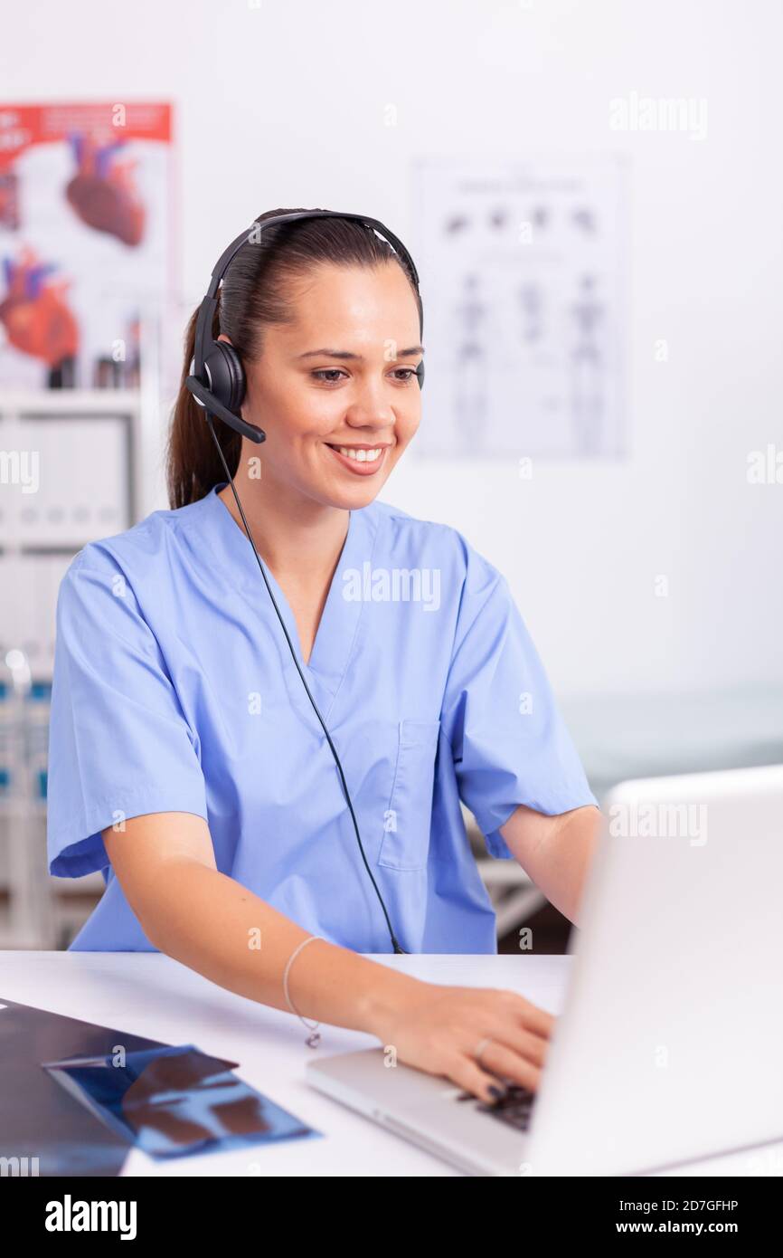 Receptionist wearing headset typing hires stock photography and images