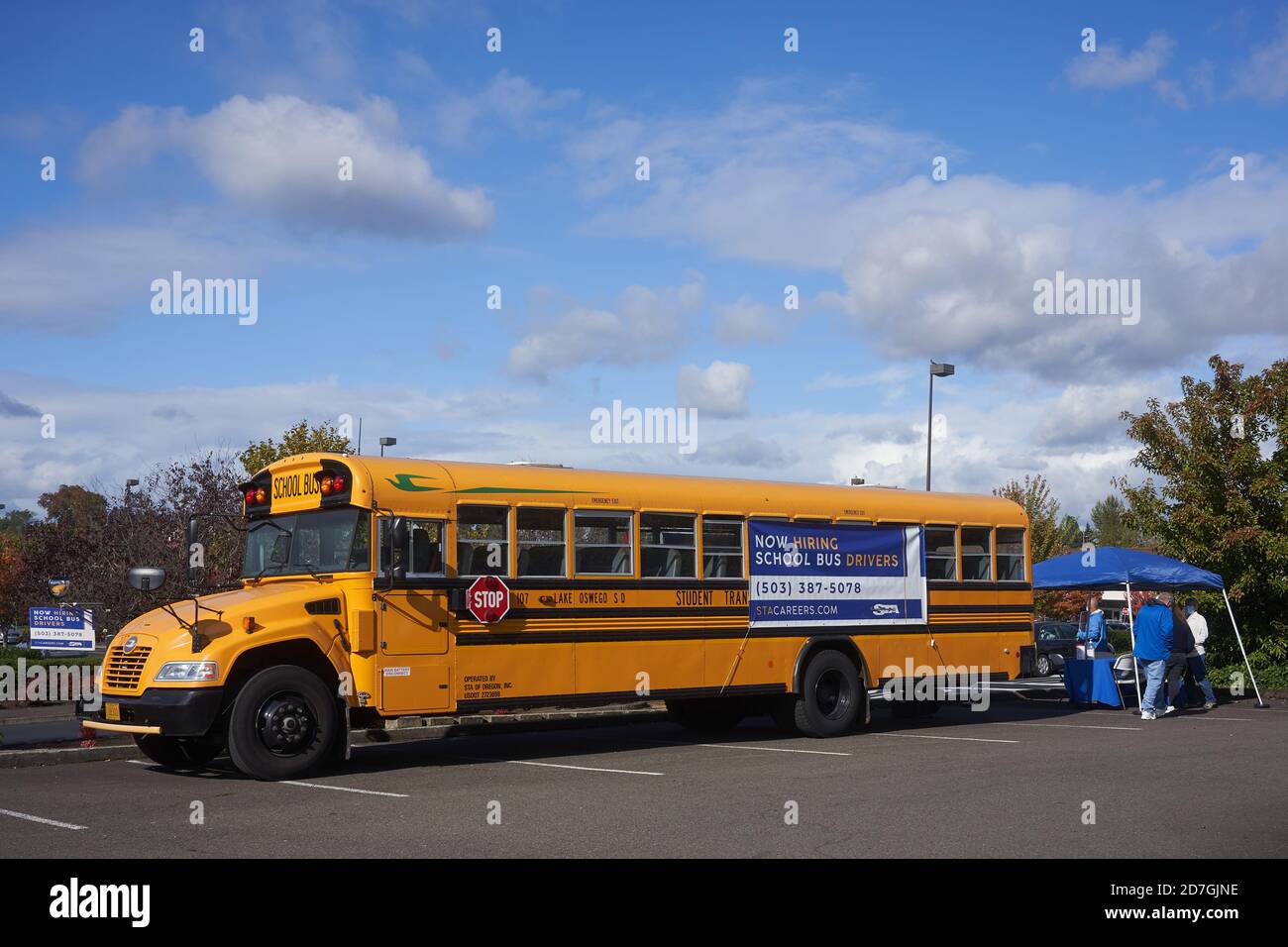 A school bus driver recruitment booth is seen in a parking lot in Tigard, Oregon, on Wednesday, October 21, 2020, amid the coronavirus pandemic. Stock Photo