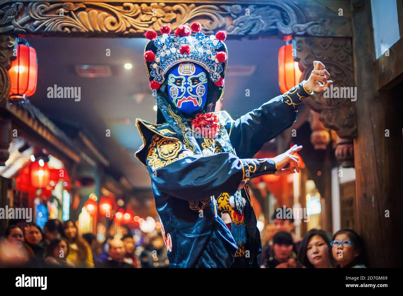 Chengdu, Sichuan Province, China - Jan 29, 2015: Chinese actor performs a public traditional face-changing art or bianlian on stage at Chunxifang Chunxilu covered street. Stock Photo