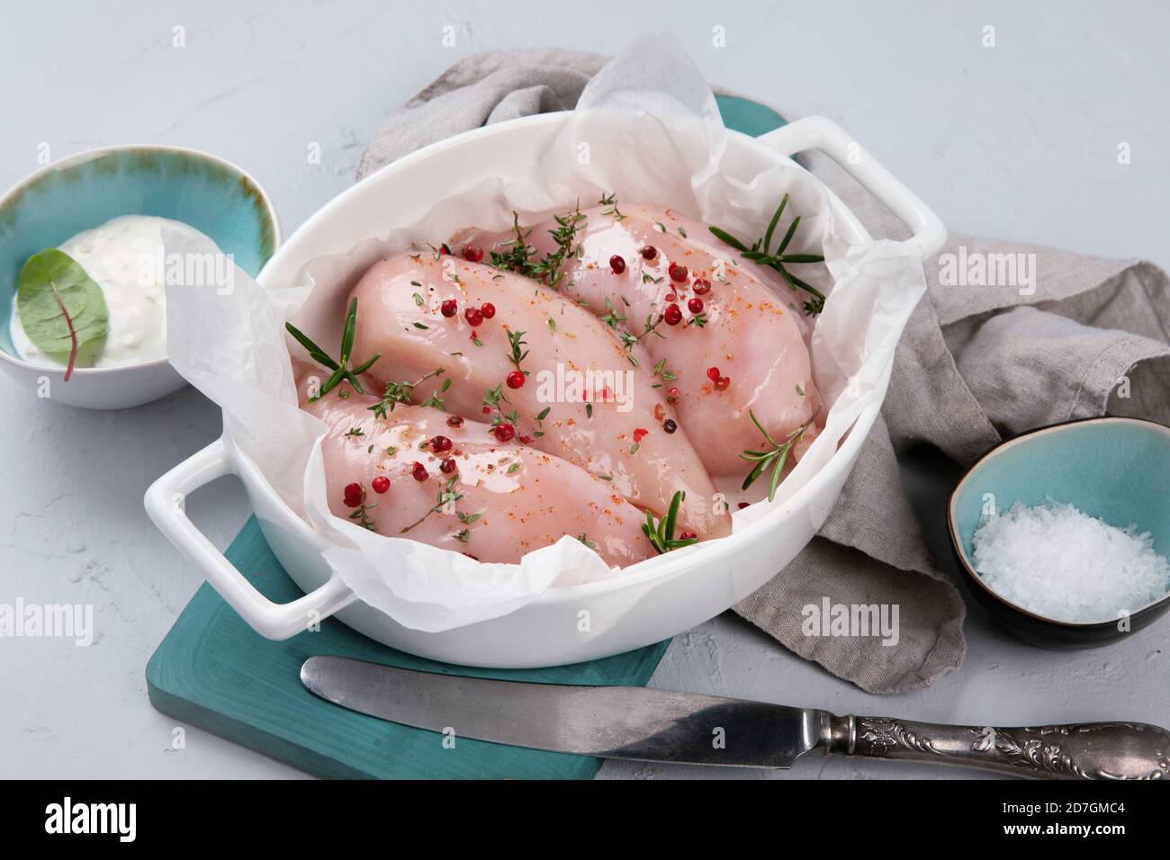Fresh raw chicken fillet with spices, herbs and vegetables. Preparing