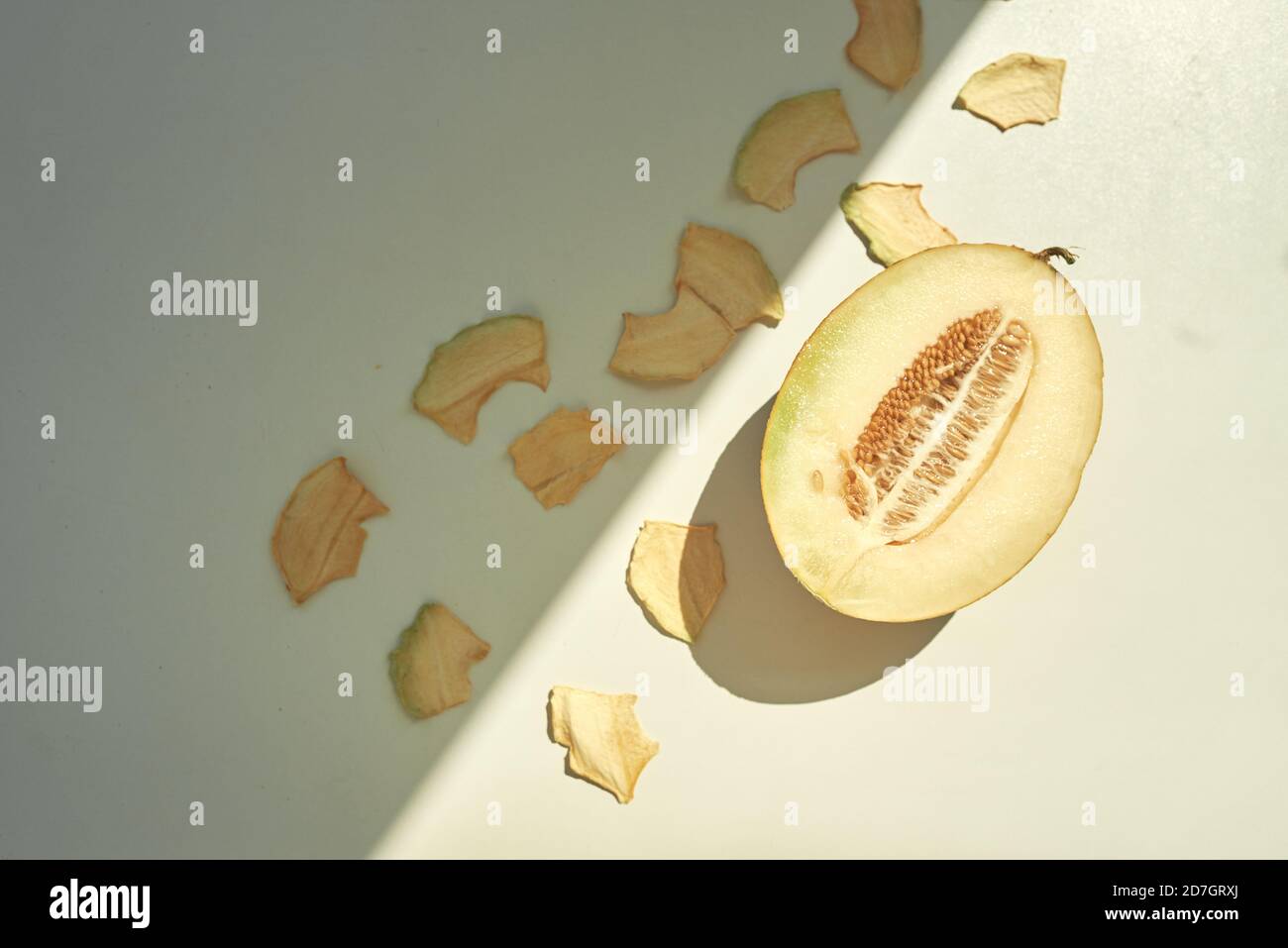 Flat lay composition with fresh and dried melon slices on white table. Stock Photo