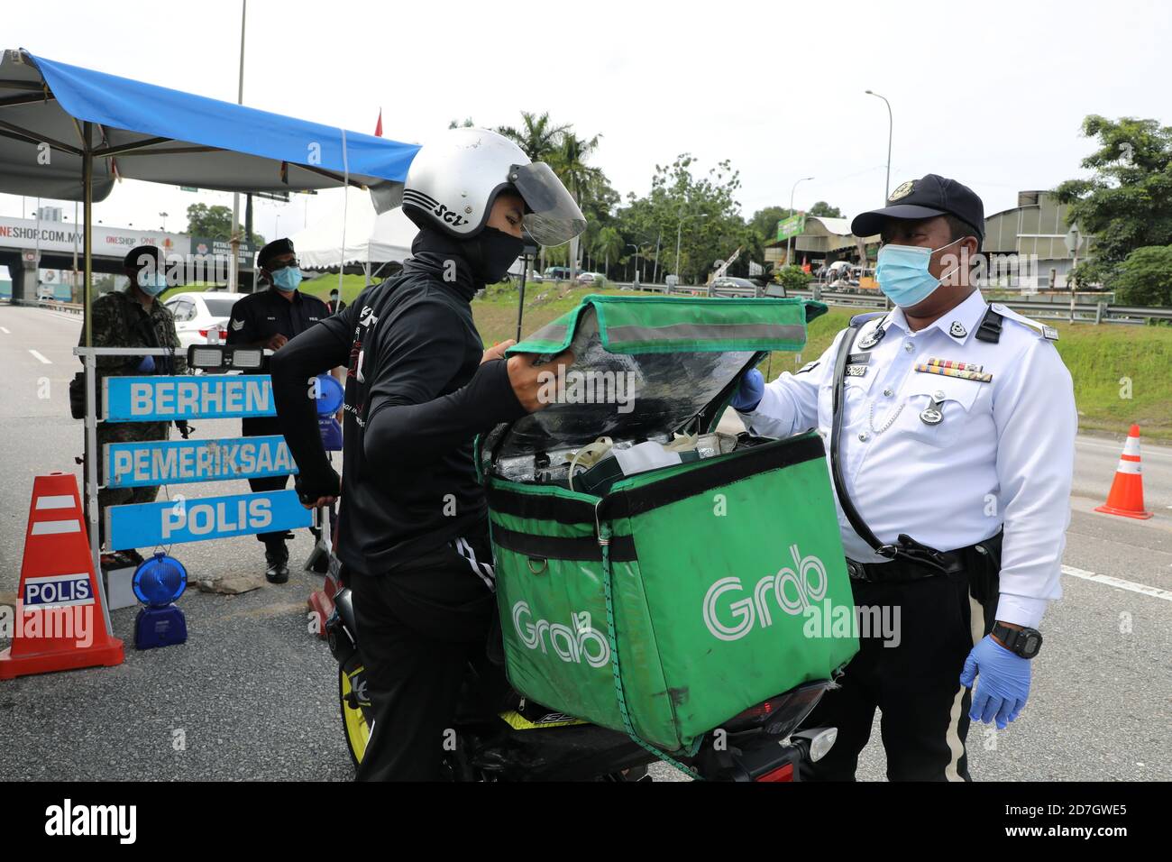 A Police Officer Checks A Grab Delivery Rider At A Roadblock To Enforce Conditional Movement Control Order Due To The Outbreak Of The Coronavirus Disease Covid 19 In Petaling Jaya Malaysia October 23
