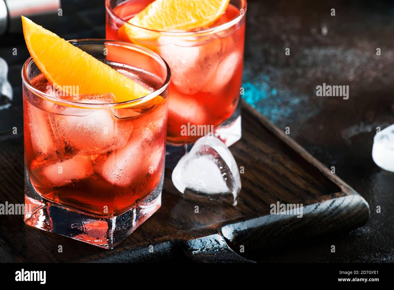 Negroni alcoholic cocktail with dry gin, red vermouth and red bitter, orange slice and ice cubes