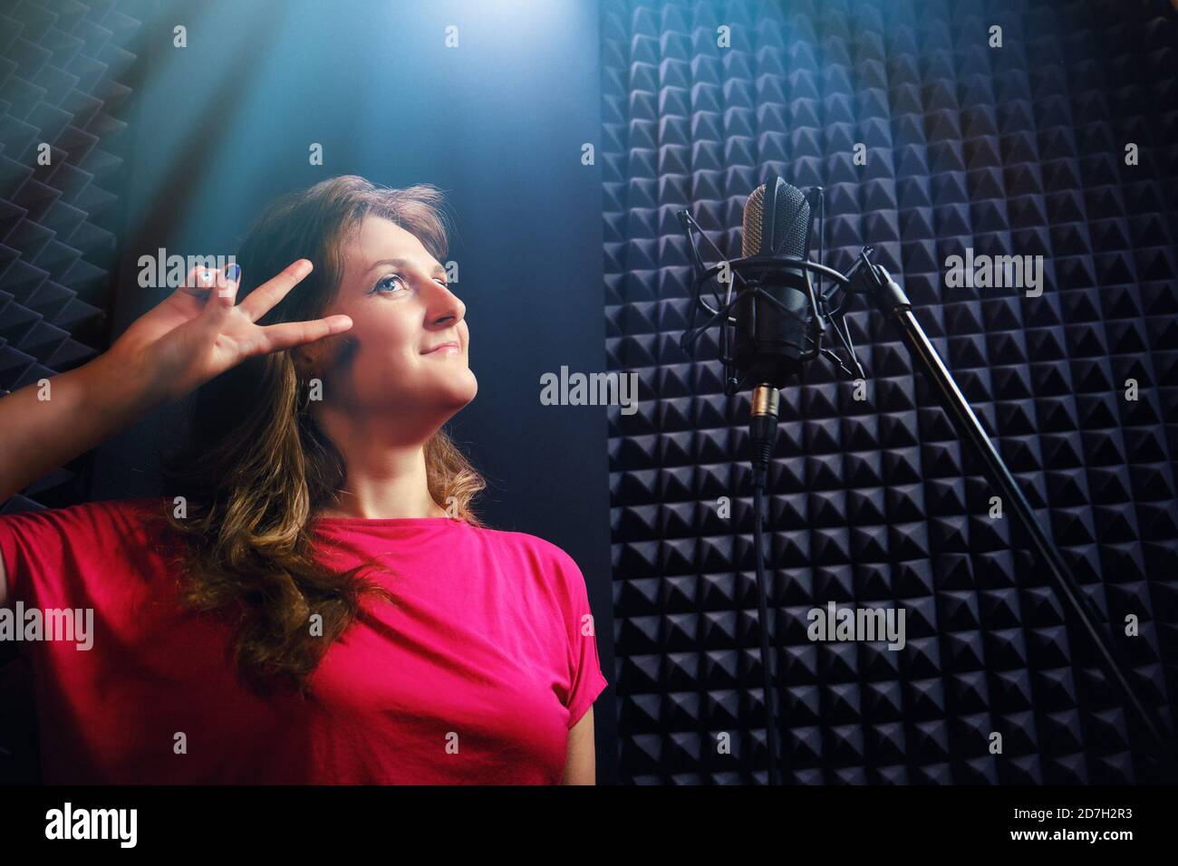 Singer in the music studio, close-up. Woman sings into a microphone on ...