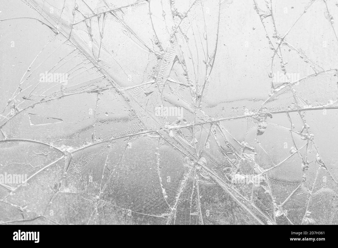 White cracked glass texture background. Texture broken glass window with cracks. Broken screen. Stock Photo