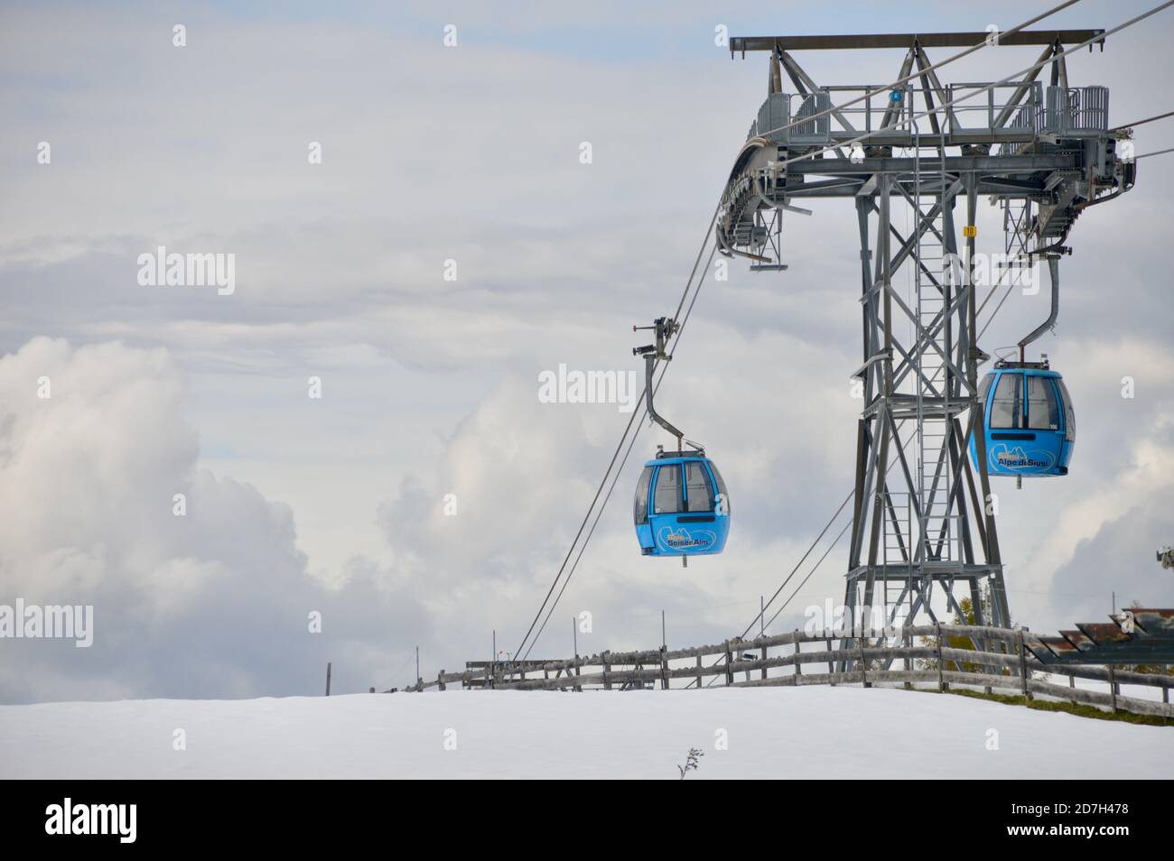 2 blaue Gondeln der Seiser Alm Bahn vor der Stütze gegen den wolkenverhangenen Himmel Stock Photo