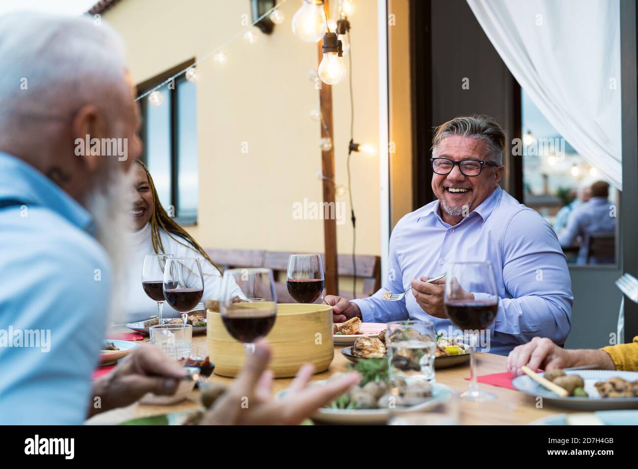 Happy senior friends having fun dining together on house patio - Food and elderly people lifestyle concept Stock Photo