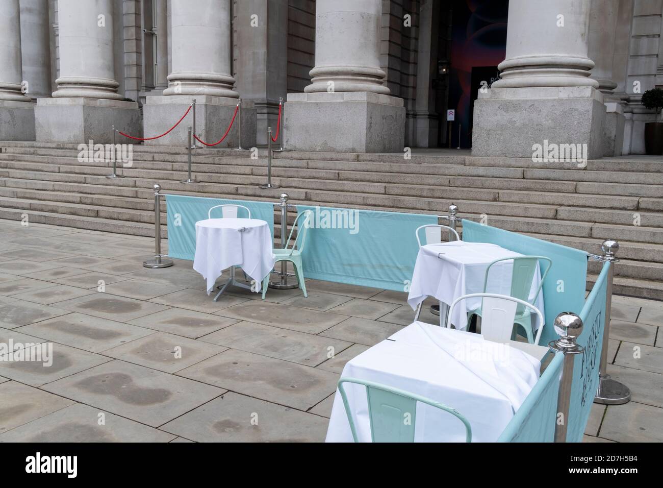 Vacant tables await customers within social distance street barriers where Fortnum & Masons have set up an outdoor restaurant and bar in front of the Royal Exchange at Bank, in the City of London, during the second wave of the Coronavirus pandemic, and when the capital is designated by the government as a Tier 2 restriction, on 20th October 2020, in London, England. Stock Photo