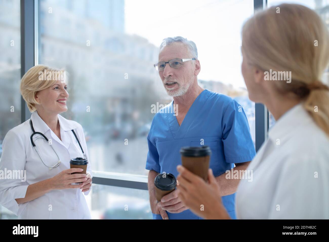 Hospital team drinking coffee, having friendly conversation Stock Photo