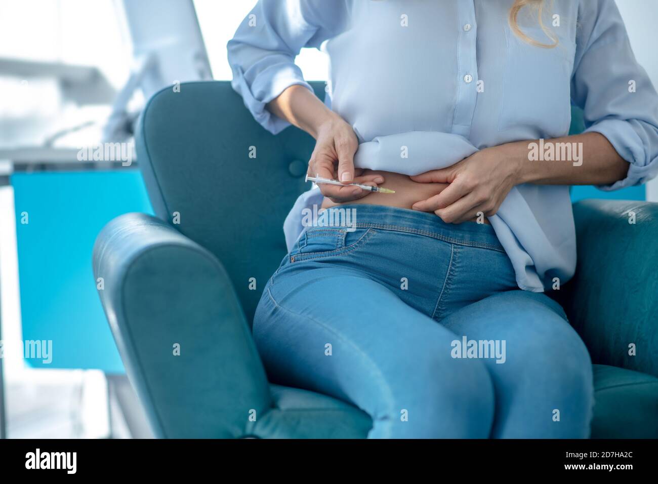Close-up of female hands injecting insulin into abdomen Stock Photo