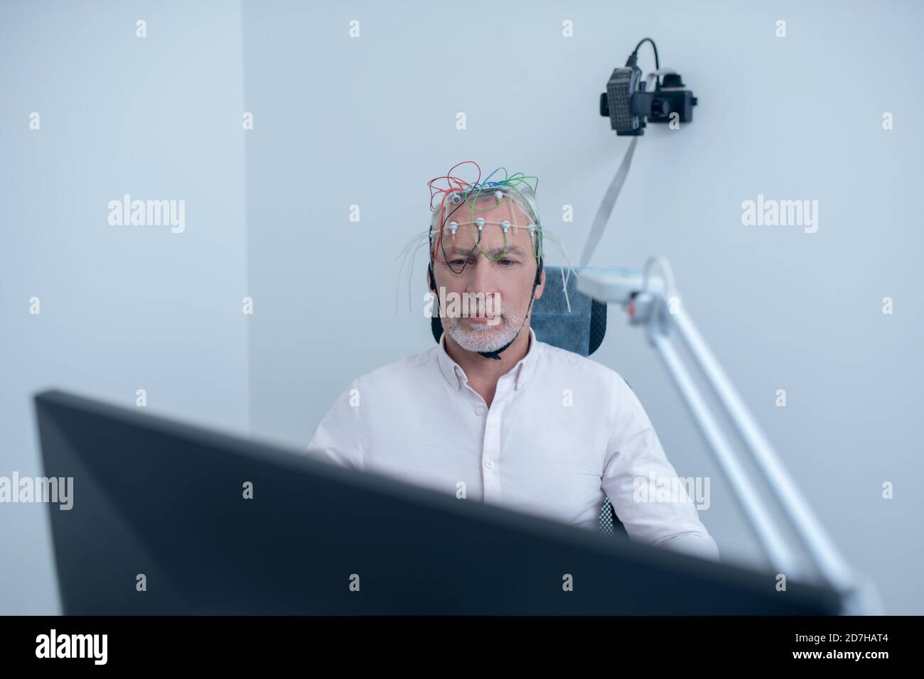 Gray-haired male patient undergoing electroencephalogram Stock Photo