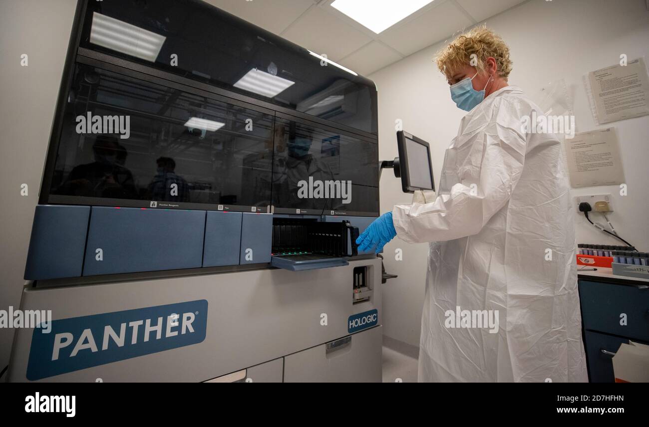Lab Instrument Rep Covid Testing A laboratory worker places Covid-19 tests inside a diagnostics machine ...