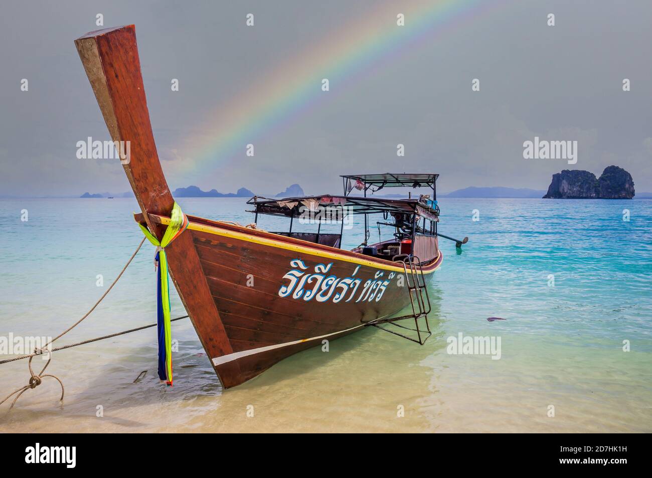 Longtail boat on beach in Thailand with rainbow Stock Photo