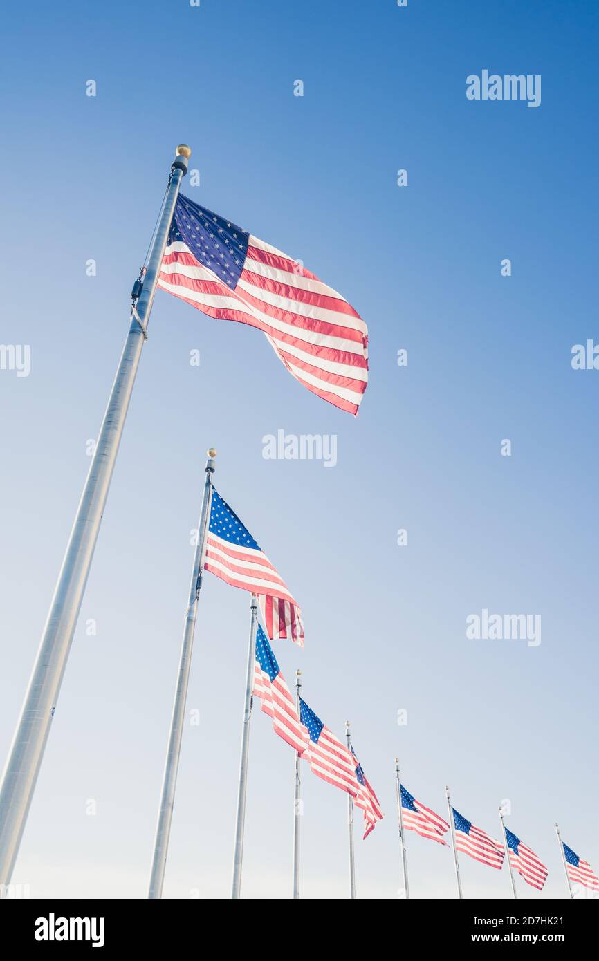 American flags on flagpoles on blue sky background Stock Photo - Alamy