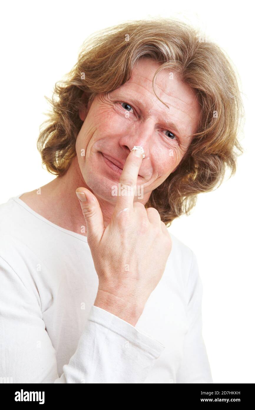 Laughing man puts cream on his face Stock Photo