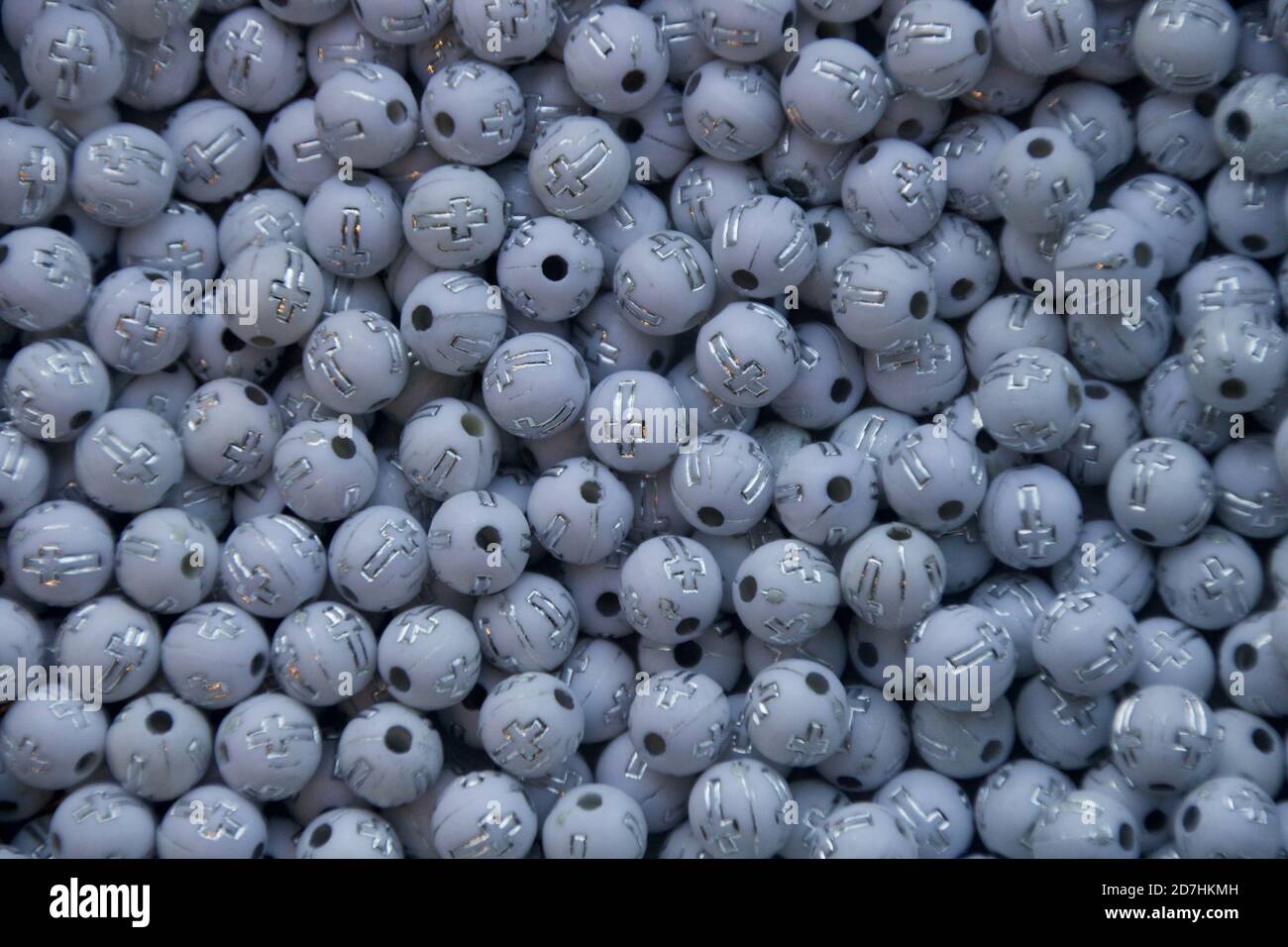 Cluster of white round shaped beads with cross engraved. Stock Photo