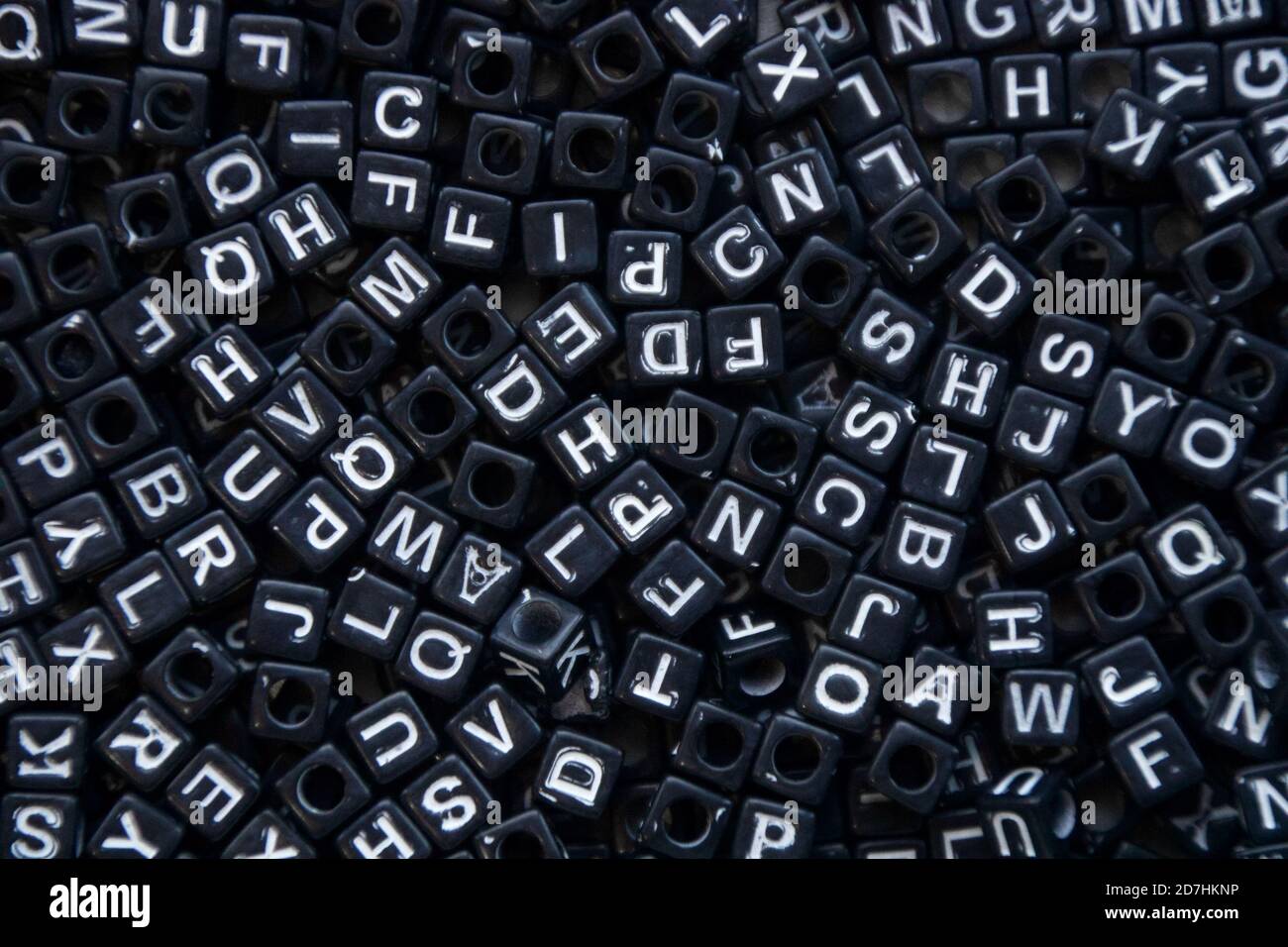 Cluster of black cube-shaped beads with white letters. Stock Photo